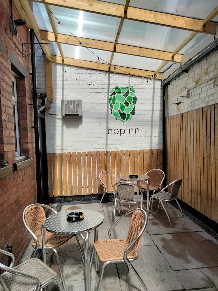 Hop-Inn outdoor seating area with string lights and wooden tables